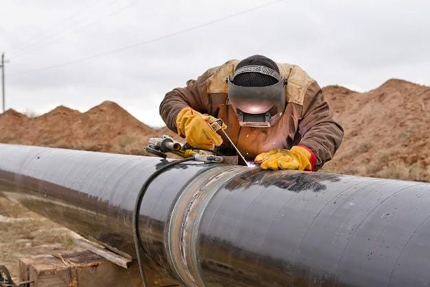 a man fixes the pipeline joint
