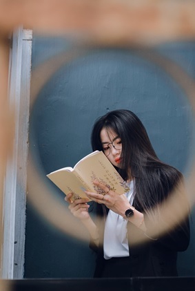 girl standing reading a book