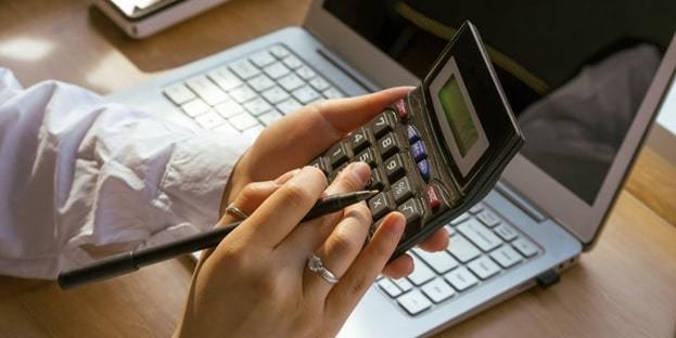 female accountant working with computer and calculator