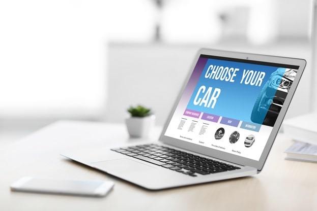 laptop on a table showing choose your car on screen