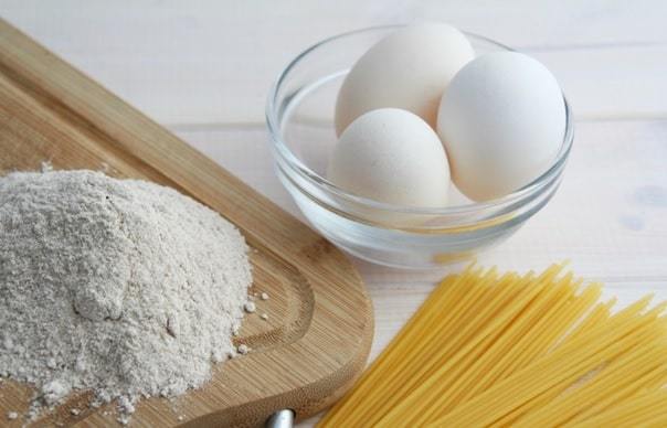 eggs in bowl, spaghetti and flour