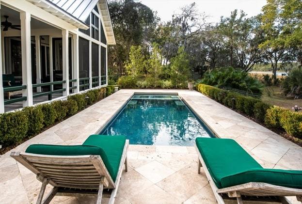 beautiful back yard pool behind luxury home with garden