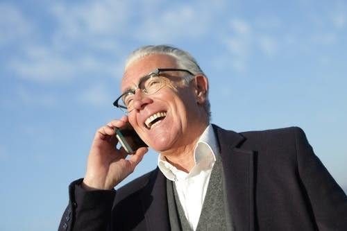 cheerful senior businessman talking on smartphone