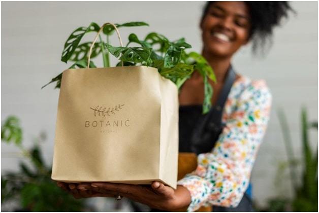 girl holding brown botanic paper packaging bag