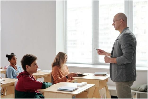 male teacher teaches students in elementary school class