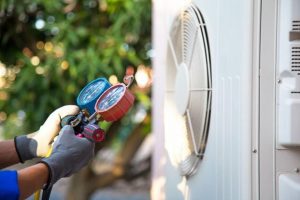 The Steps to Having HVAC Installed in Your Home technician checking refrigerant using manifold gauge for filling home air conditioning
