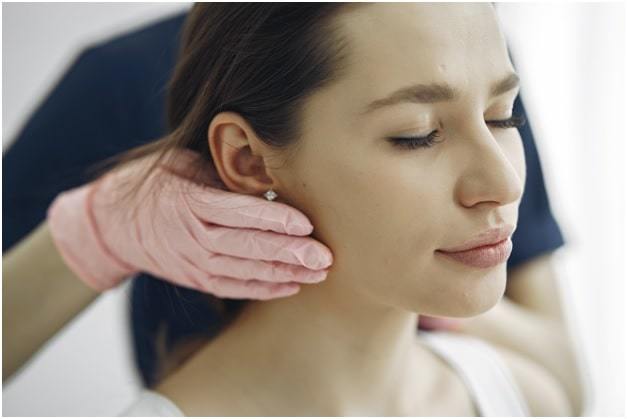beautician doing face massage for female customer