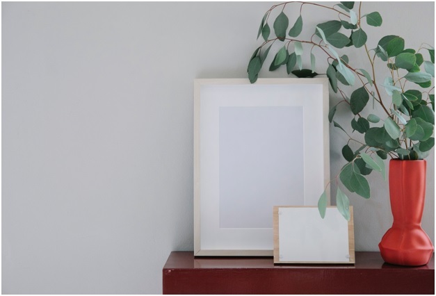white blank frames and potted plant on brown wooden table