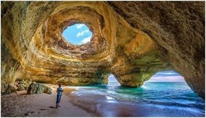 a person with camera in benagil cave portugal