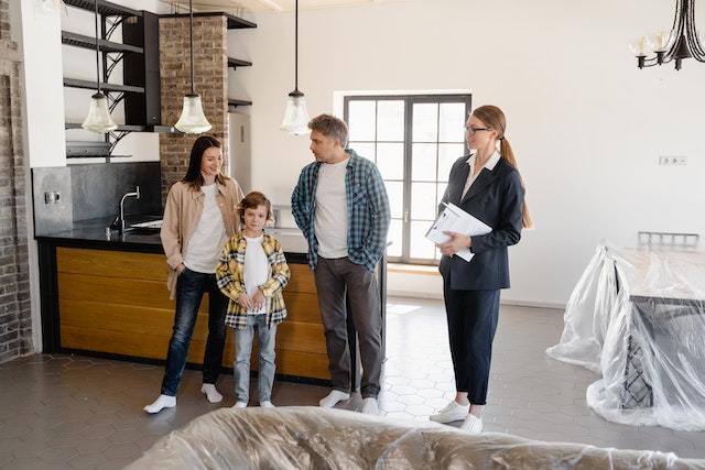 Real estate agent showing a house to parents and their young son.