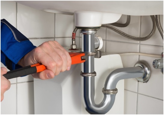 plumber fixes bathroom sink drain pipe