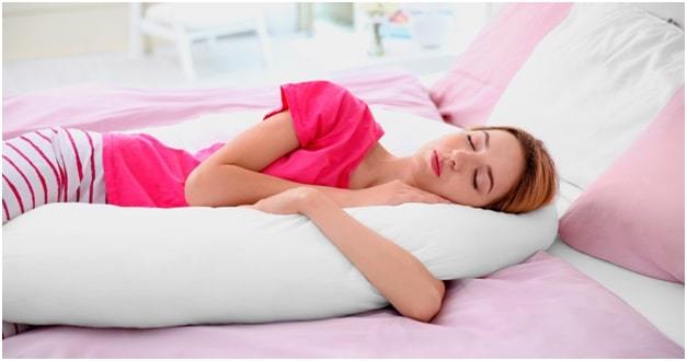 young pregnant woman sleeping with body pillows