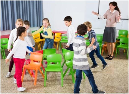 children playing music chairs in classroom