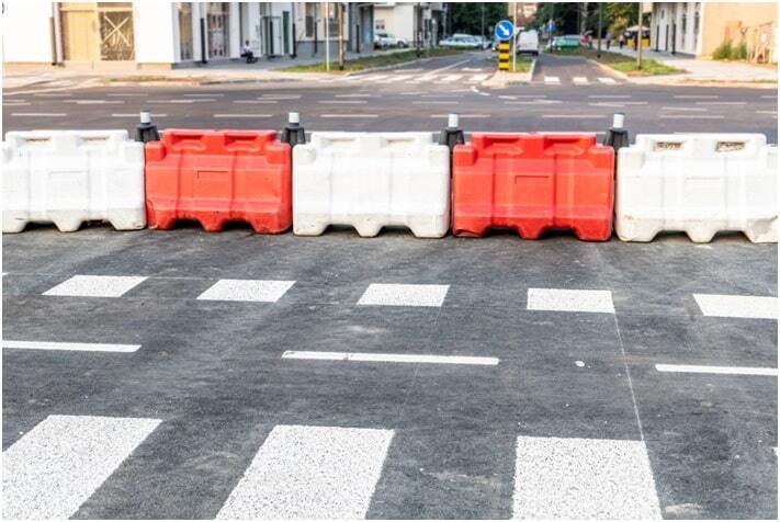 white and red plastic road safety barriers on the new highway street reconstruction