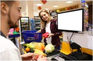 male cashier checking out goods in supermarket
