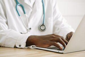 a doctor typing on a laptop