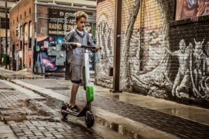 boy standing on black and white kick scooter