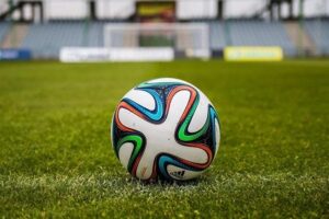 multicolored soccer ball on green field