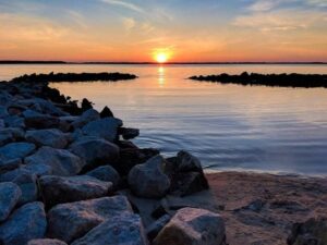 waterfront, stony beach sunrise in ocean city, maryland