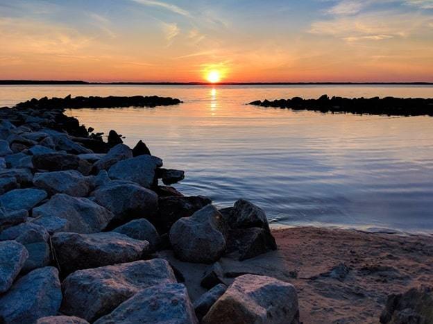waterfront, stony beach sunrise in ocean city, maryland