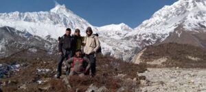 four people with backpacks standing on the mountain