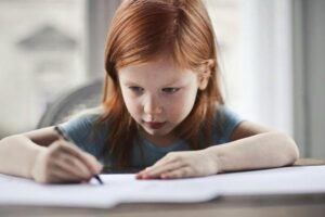 Is Your Child Struggling with Writing? Signs It's Not Just About Practice girl writing on paper