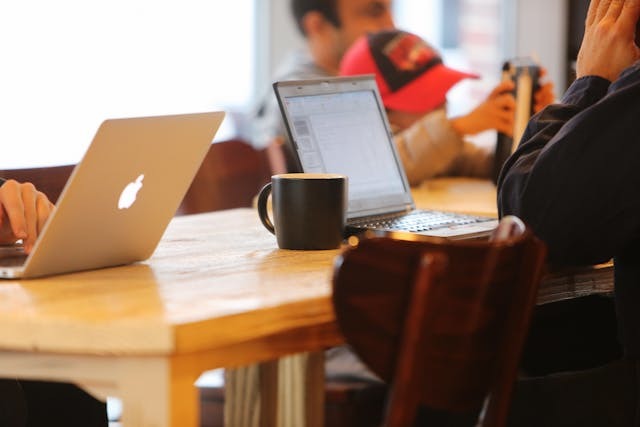 coffee cup next to laptop on table