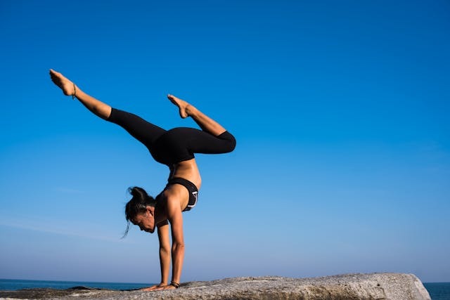woman with arms outstretched against blue sky