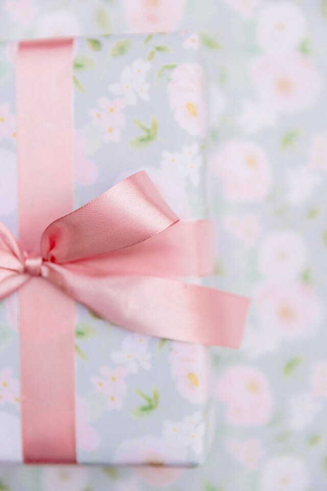 a present wrapped in pink ribbon with a pink bow