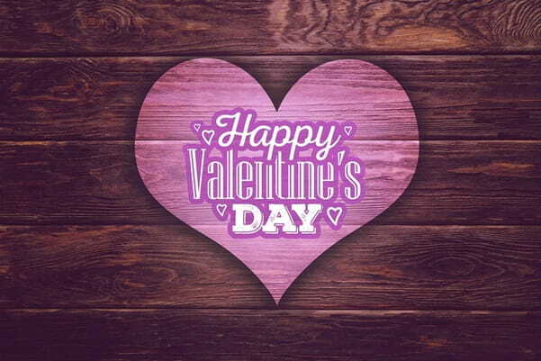 valentine day written in heart shape on table background