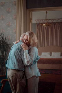 elderly couple hugging at home