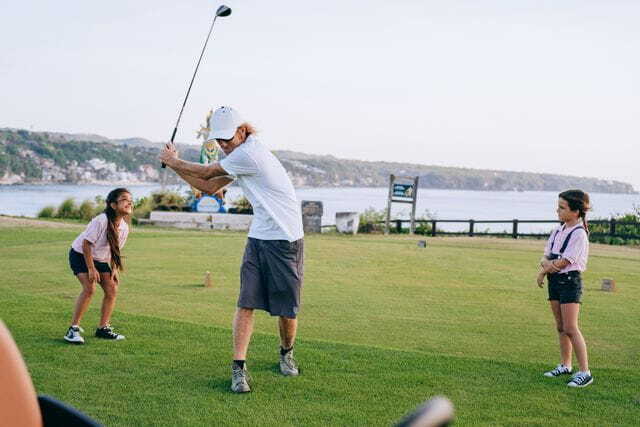 man playing golf together with his children