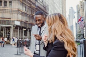 4 Market Trends Shaping the Botanical Inhalation Industry two business professionals engage in lively conversation on an urban street, sharing insights.