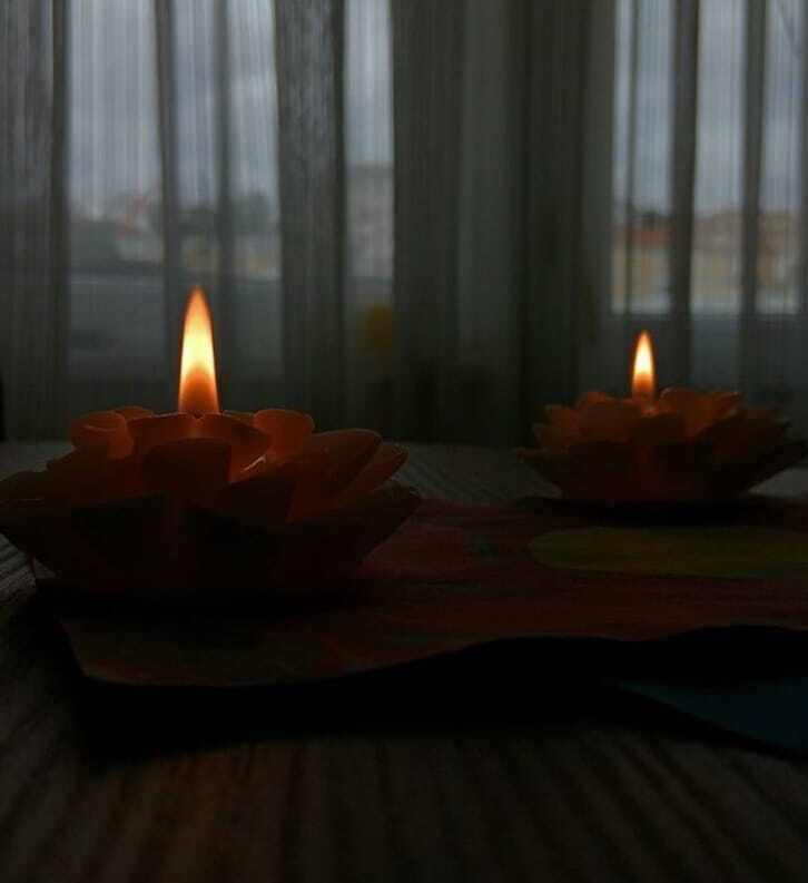 a serene image of decorative candles casting a warm glow indoors on a wooden table
